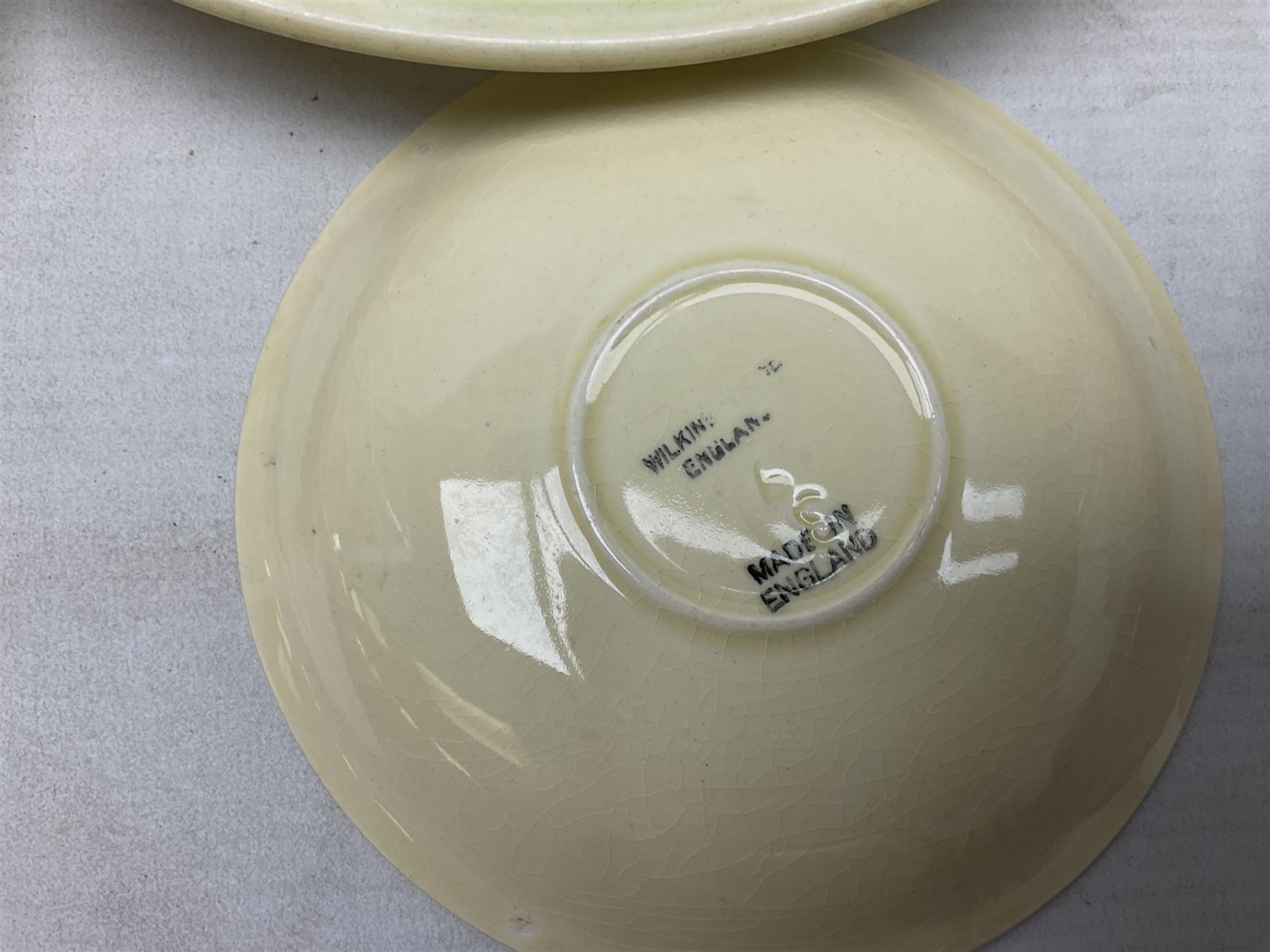 Clarice Cliff for Newport Pottery Corolla pattern tea and dinner wares, comprising triangular bowl, four side plates, two shallow bowls and teacup (a/f), together with a Clarice Cliff Wilkinson twin handled soup bowl and unassociated saucer both decorated with pink and yellow flowers, together with other mid century ceramics comprising Parrott and Company Coronet Ware, and Royal Staffordshire AJ. Wilkinson Ltd dinner wares