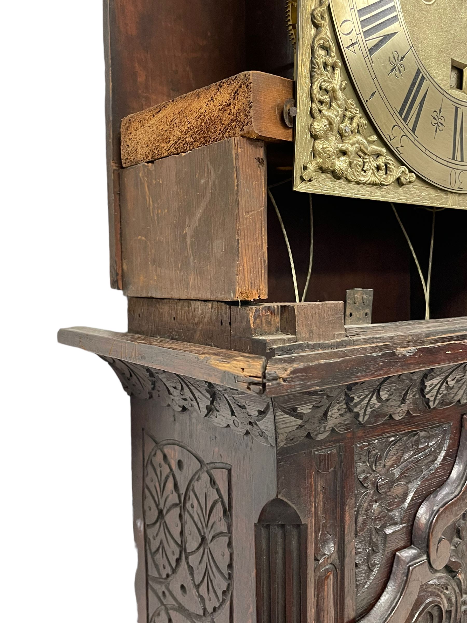 18th-century profusely carved oak longcase clock - with a pagoda pediment, upstands and carving, 
 break arch hood door flanked by reeded pilasters with brass capitals, trunk with canted corners and a spire topped door, square plinth with applied skirting, break arch brass dial with wheatsheaf engraving and cast cherub and crown spandrels, engraved break arch with the London clockmakers name John Gordin, silvered chapter ring with Roman numerals, five minute Arabic's, minute and quarter hour tracks, matted dial centre with ringed winding holes, square date aperture and seconds ring, dial pinned to a five pillar movement with inside countwheel striking, striking the hours on a cast bell. With weights and pendulum. John Gordin, is possibly a mis-spelling or phonetic spelling of John Gordon, of London, who worked from Ludgate Street in the parish of St. Gregory by St. Pauls. Apprenticed in 1689 and died in 1732 when his will was proven.
