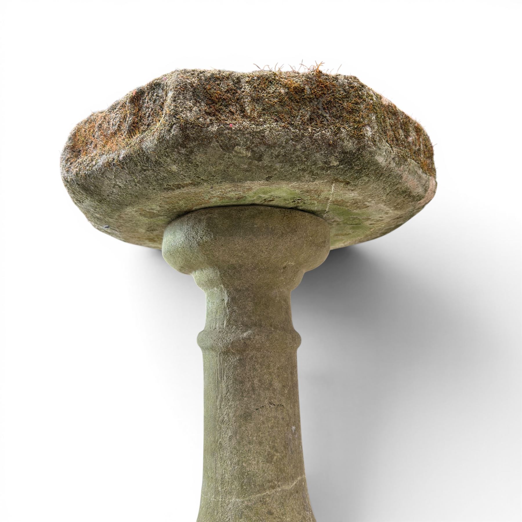 19th century weathered sandstone birdbath, the octagonal canted dished top raised on a ring turned flared pedestal, with four carved stylised dolphins to the squared base