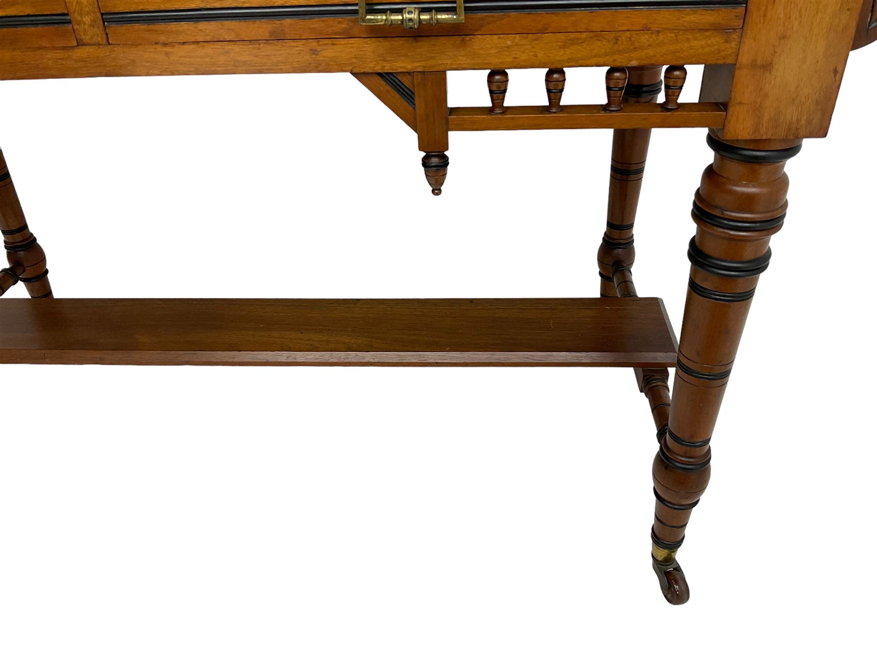 Late Victorian Aesthetic Movement walnut and inlaid ebony dressing table, swing mirror back with shell carving and spindle support rail, fitted with two trinket drawers and single frieze drawer, raised on ring turned supports with castors