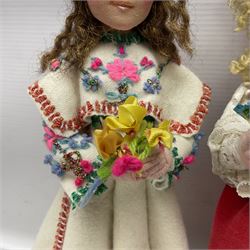 Anna Meszaros Hungary - three hand made needlework figurines, each as a young girl in regional costume holding a bouquet of flowers H30cm (3)  Auctioneer's Note: Anna Meszaros came to England from her native Hungary in 1959 to marry an English businessman she met while demonstrating her art at the 1958 Brussels Exhibition. Shortly before she left for England she was awarded the title of Folk Artist Master by the Hungarian Government. Anna was a gifted painter of mainly portraits and sculptress before starting to make her figurines which are completely hand made and unique, each with a character and expression of its own. The hands, feet and face are sculptured by layering the material and pulling the features into place with needle and thread. She died in Hull in 1998.