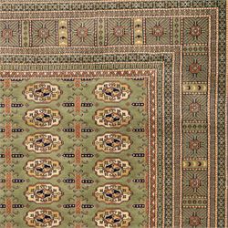 Turkish Bokhara design rug, olive green field decorated with an all-over design of repeating gul motifs arranged in rows, enclosed by a series of narrow and wide geometric borders with diamond and star devices 