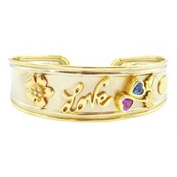 18ct gold 'Love' torque bangle, set with a heart cut pink sapphire and blue topaz, stamped Sidra 750