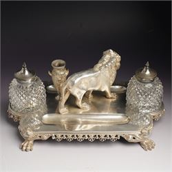 19th century Walker & Hall, silver plated inkstand, oblong and on four paw feet, the border decorated with pierced shell design, each side with a pen-rest, with two cut-glass bottles and central lion and urn finials, engraved to the front with an inscription, H15cm, L30cm