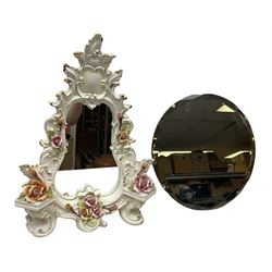 Two mirrors, comprising Art Deco style circular example, and ceramic example of shaped form with encrusted rose detail 