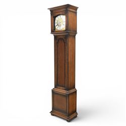 Early 20th century oak longcase clock, square brass dial with engraved foliate spandrels and centre, silvered Roman chapter ring with Arabic minute track, Westminster chime movement, the plain case with glazed arched trunk door and moulded plinth