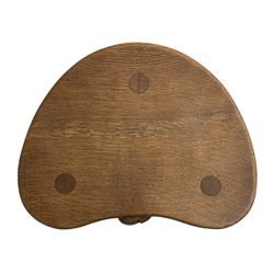 'Mouseman' oak three-legged stool, kidney shaped dished seat carved with mouse signature to edge, by Robert Thomas of Kilburn