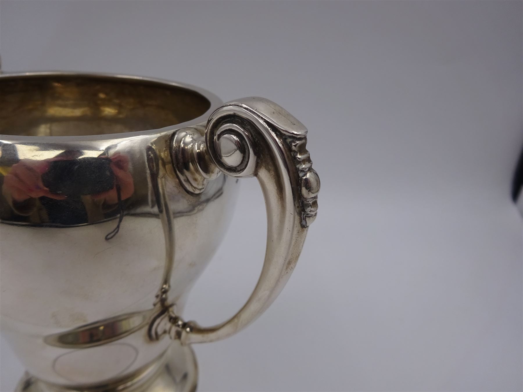 1920s silver trophy cup, of typical form, with twin C scroll handles, upon stepped circular base, hallmarked Birmingham 1926, maker's mark worn and indistinct, H14cm