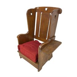 Arts and Crafts design oak reading wingback armchair, high back with pierced heart design, drop-leaf side table to one arm
