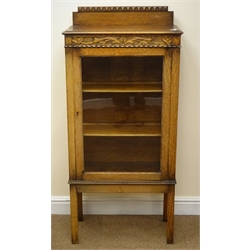  Early 20th century narrow oak display cabinet, raised back, moulded top, glazed door enclosing two shelves, rectangular supports, W61cm, H132cm, D32cm  