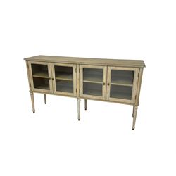 Washed finish sideboard or dresser, rectangular top over four glazed cupboard doors enclosing single shelf, raised on fluted tapered supports 