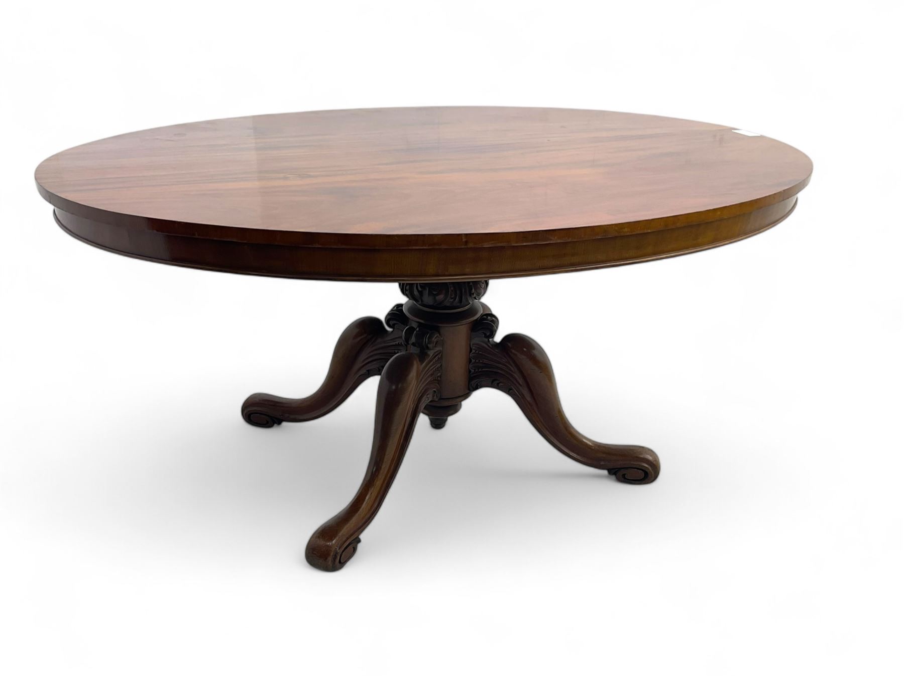 Victorian mahogany breakfast loo table, oval tilt-top on turned pedestal, quatrefoil out-splayed carved supports, scroll carved terminals with brass castors