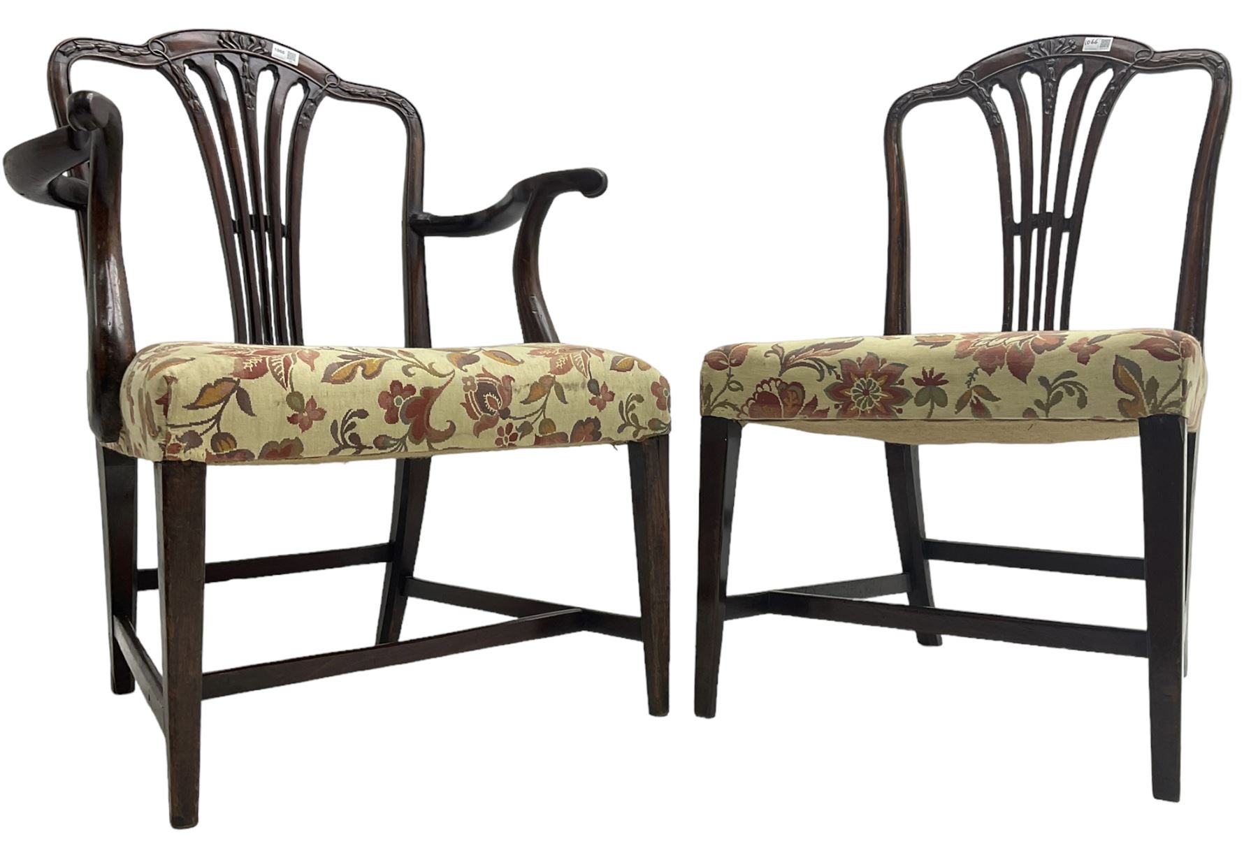 George III Hepplewhite design mahogany elbow chair and matching side chair, cresting rail carved with bellflowers over pierced and flared splat, seats upholstered in floral patterned fabric, raised on square tapering supports united by stretchers