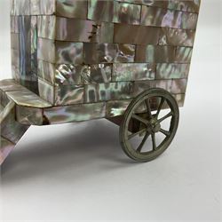 19th century French souvenir jewellery casket in the form of a bathing machine, having mother of pearl panelled tiled effect body, hinged roof/cover revealing a blue silk fitted interior with cushioned base, two silvered metal wheels, abalone shell door and mother of pearl steps, inscribed 'Berck Plage' in blue, H12cm, W13cm 