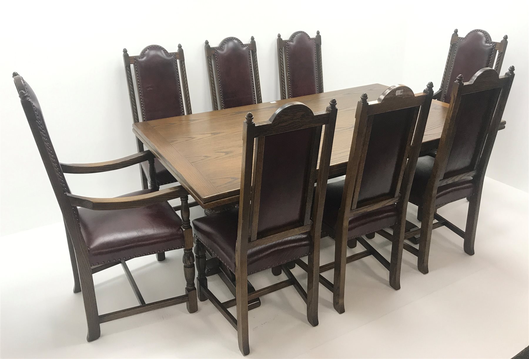  Old Charm oak drawer leaf dining table, carved cup and cover supports on shaped sledge feet joined by single stretcher (W275cm extended, 183cm closed, H76cm, D108cm) and set eight (6+2)  chairs, arched cresting rail with finials, studded leather back and seat, cup and cover supports joined by stretchers (W  