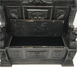  Victorian heavily carved oak settle, panelled back with gryphons and mask heads, lifting seat with lion carved arms above panelled inverted breakfront , W137cm, D50cm, H148cm  