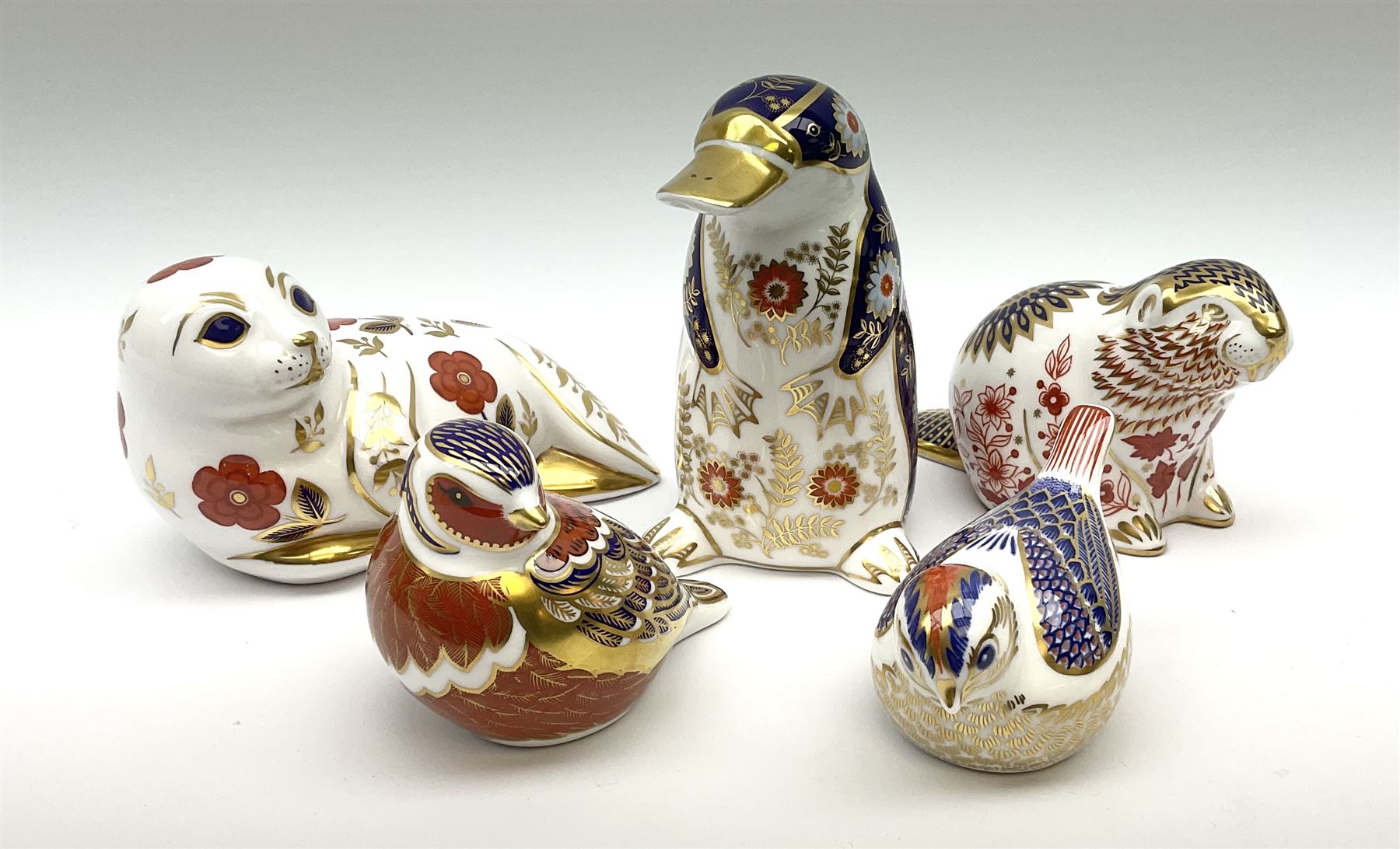 Five Royal Crown Derby paperweights, comprising Chaffinch, and Goldcrest, each with gold stopper, and box, example modelled as a Beaver with silver stopper, and two further examples lacking stoppers. 