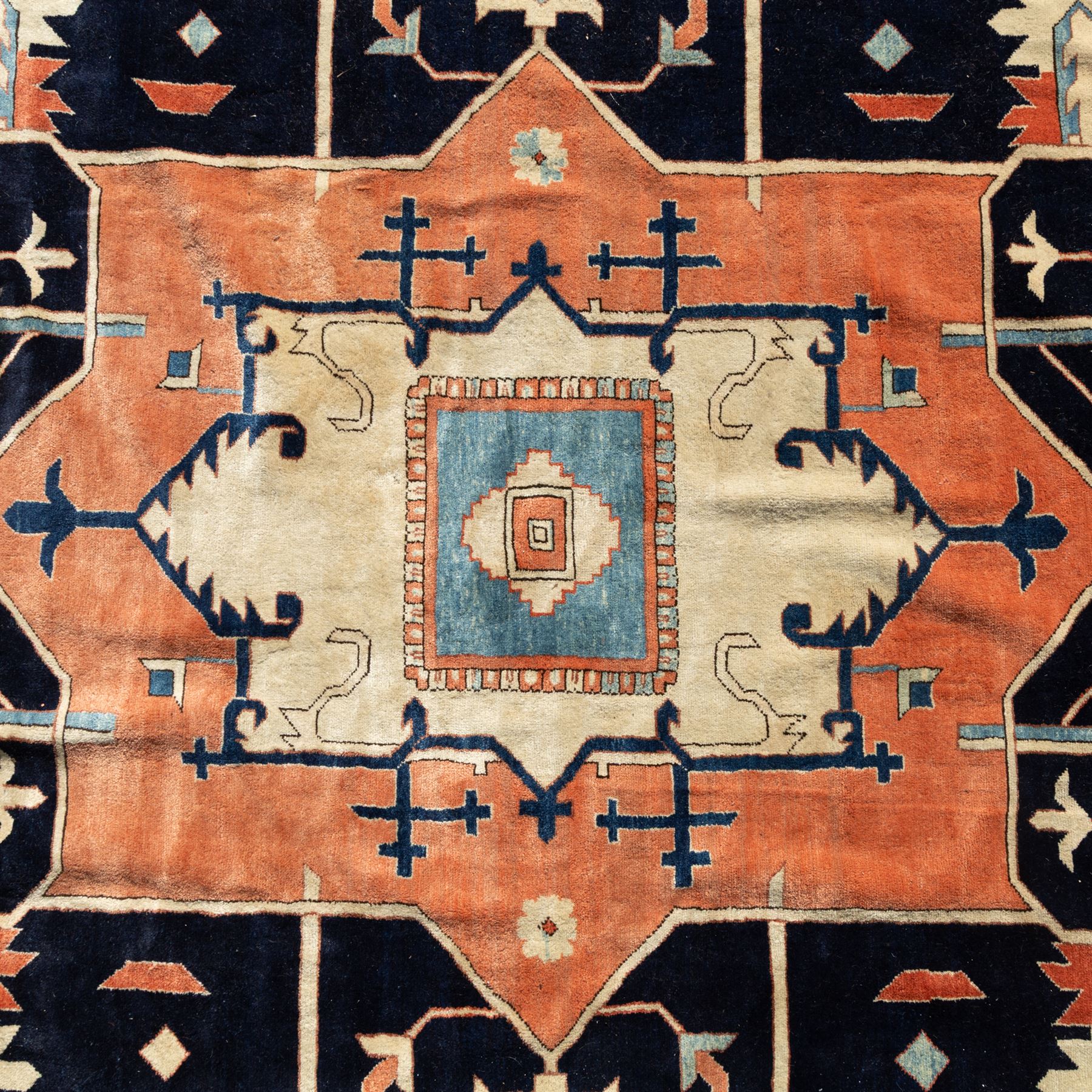 Exceptionally large Northwestern Persian Heriz, hand-knotted carpet, madder red field with a bold stepped medallion in indigo and ivory, and light blue spandrels within a dark indigo border of rosettes and angular vine motifs 





