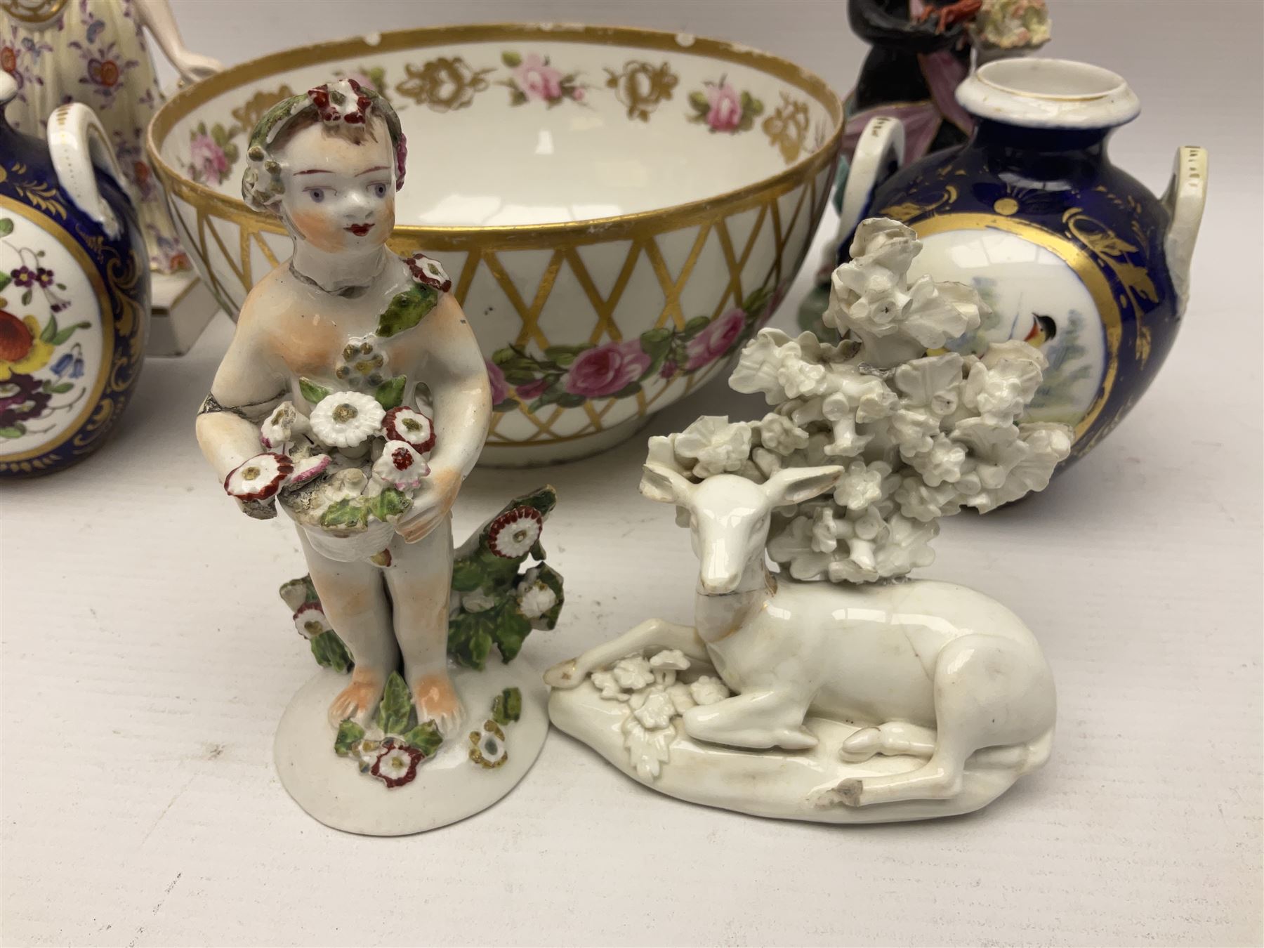 Group of 18th and 19th century ceramics for repair and restoration, to include an 18th century Derby figure emblematic of the Continent of Africa, pair of small 19th century Derby vases, painted with birds and floral spray, 19th century Derby slop bowl decorated in the 594 pattern with pink roses against gilt trellis, 19th century Derby figure of a recumbent deer, Serves style box, and two further figures