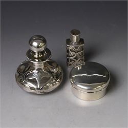 Two early 20th century silver pill/patch boxes, together with two glass perfume bottles with silver overlay and stoppers, all stamped or hallmarked, smallest box D2cm, largest bottle H7cm
