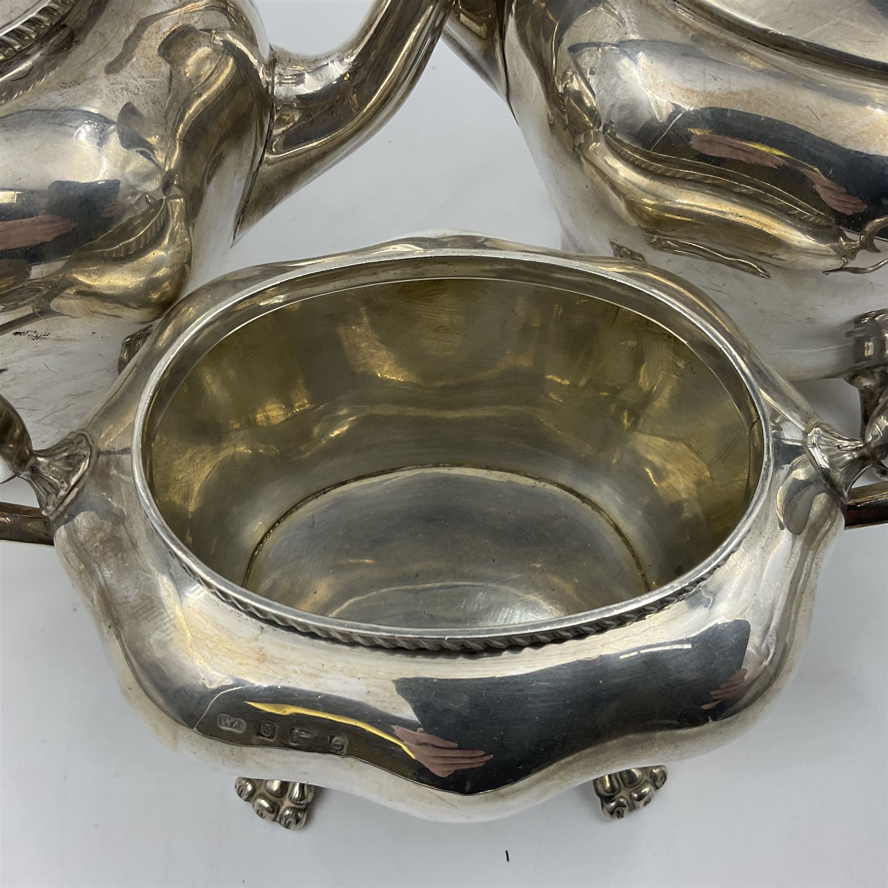 Five piece Edwardian silver tea service, comprising teapot and coffee pot, each with ebonised scroll handle, tea caddy with hinged cover, twin handled open sucrier, and milk jug, each of rounded bombe form, upon four paw feet, hallmarked William Adams Ltd, Birmingham 1904 and 1905, coffee pot H26cm
