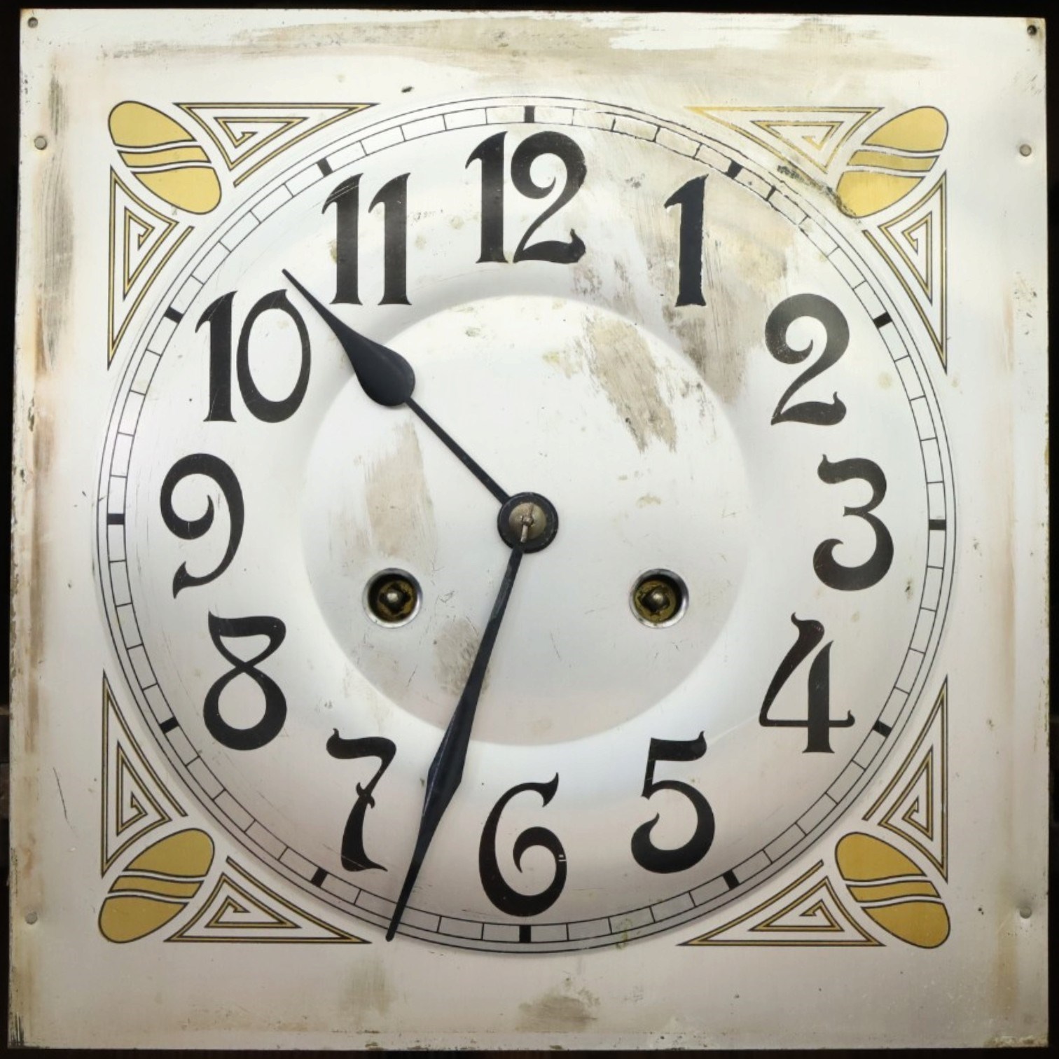 Art Deco style oak wall clock, moulded cornice above a silvered dial with Arabic numerals and geometric spandrels, glazed door with geometric bevelled glass panels enclosing a circular pendulum, on a stepped moulded base