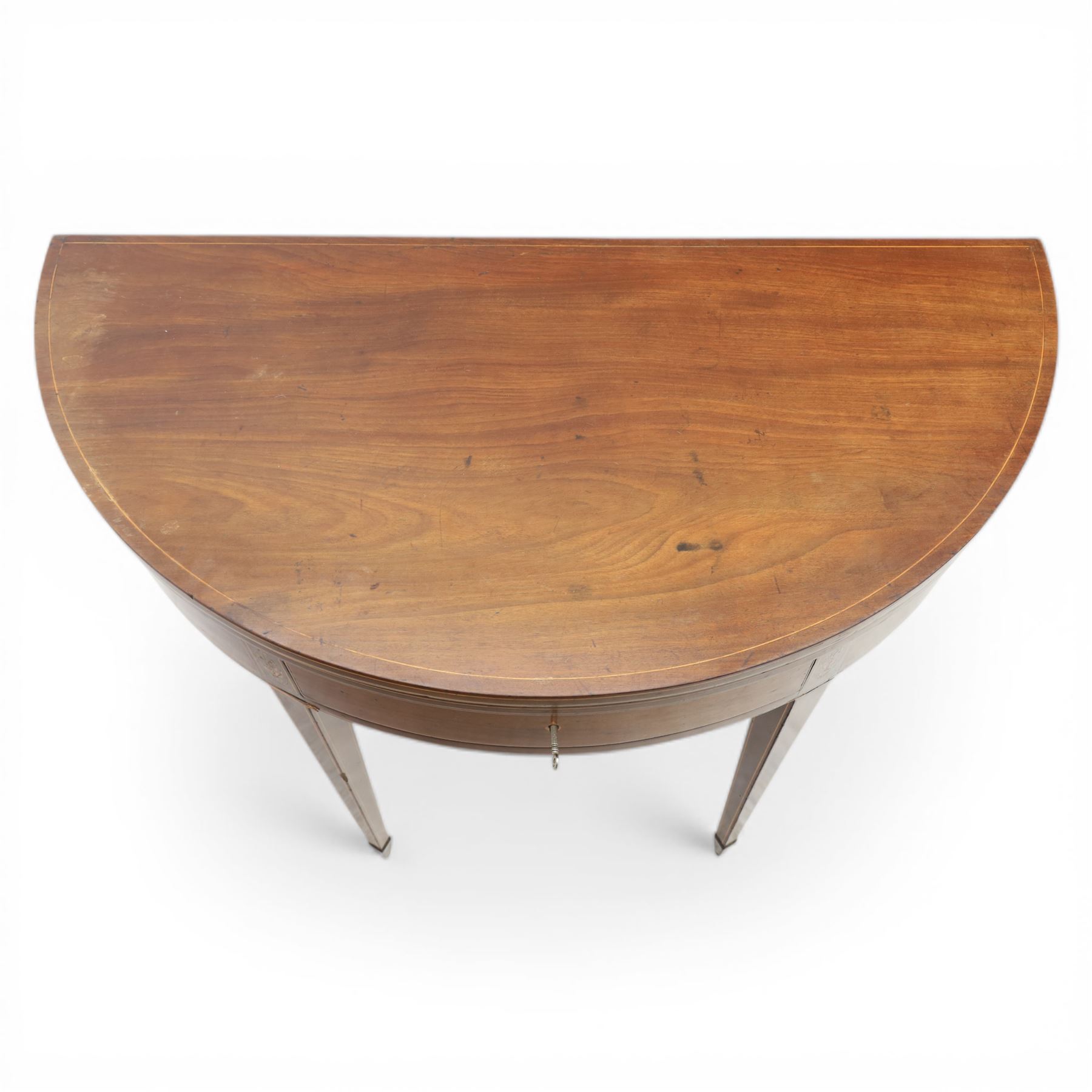 George III Scottish inlaid mahogany demi lune tea table, the curved fold over top opening to reveal a circular top with inlay to edge, above a frieze drawer with key, raised upon tapering inlaid legs with spade feet