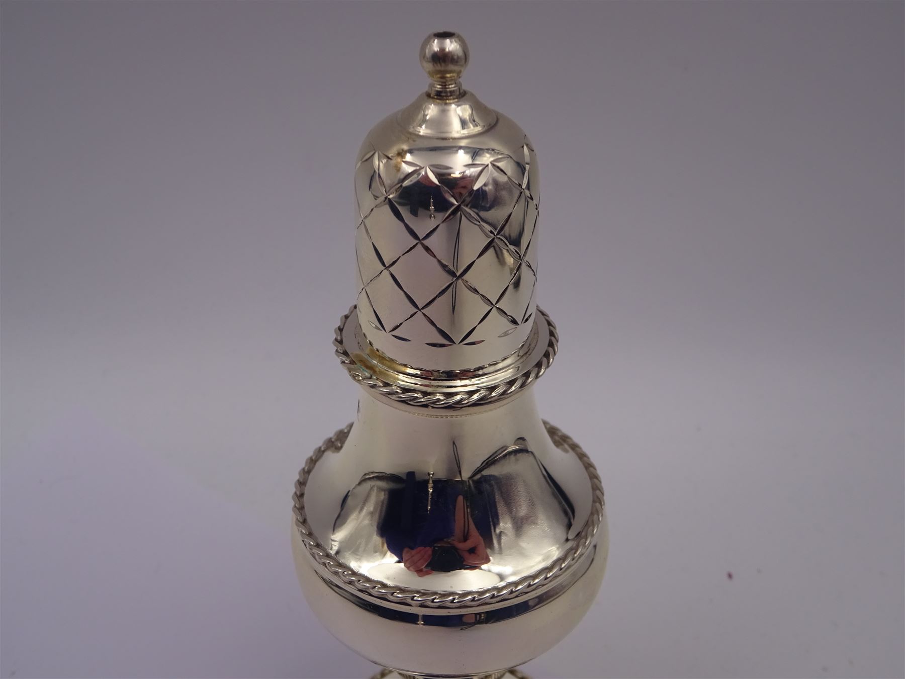 Modern silver two piece cruet set, comprising salt shaker and pepper shaker, both of waisted form with engraved rope twist borders, the removable pierced covers each with engraved lattice decoration, upon a circular spreading foot, hallmarked Laurence R Watson & Co, Birmingham 1989, H14.5cm, contained within velvet lined fitted case