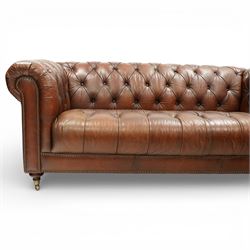 Ullswater - late 20th century brown leather chesterfield sofa, deep button tufted back, arms and seat, classic rolled arm form with studded borders to the arms and base, raised on turned feet with castors