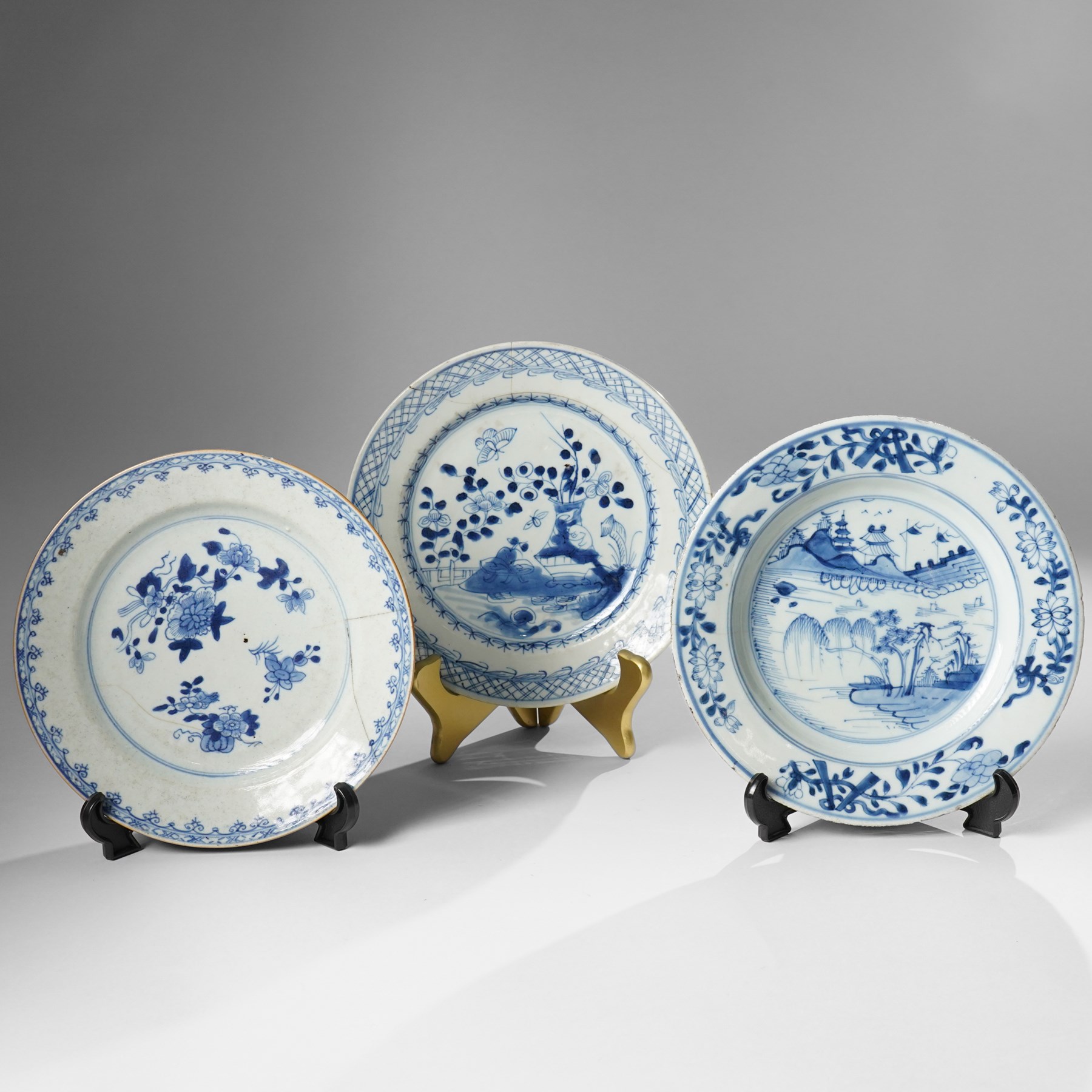 Three Chinese Kangxi period blue and white plates, painted in underglaze blue with various patterns, including Butterfly and Rockery, Pagoda and River Landscape, and floral sprays, each approx. D23cm (3)