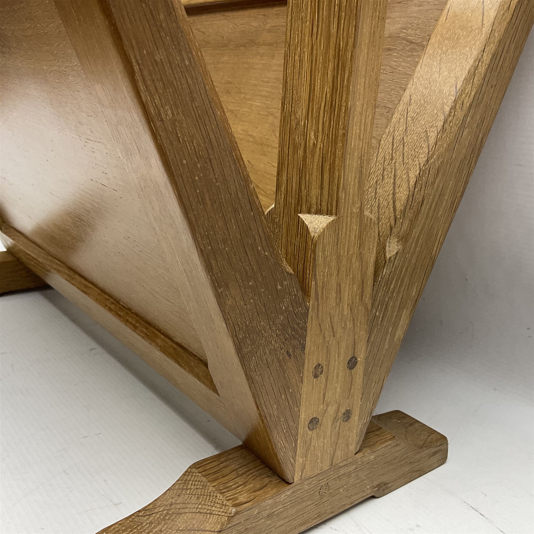 Mouseman - oak magazine rack, the top rail pierced with handle and carved with mouse signature, octagonal supports with two panelled and splayed sides, on sledge feet, by the workshop of Robert Thompson, Kilburn 