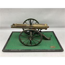 Scratch built brass model of an 1861 Gatling Gun with rotating barrels, hinged cover revealing mechanism, on metal bound wooden spoked wheels and rectangular base L47cm H22cm