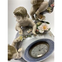 A Lladro mantel clock modelled as a globe with inset clock, surmounted by four putti and floral garlands, with blue printed mark and impressed 5973 beneath, H29cm.