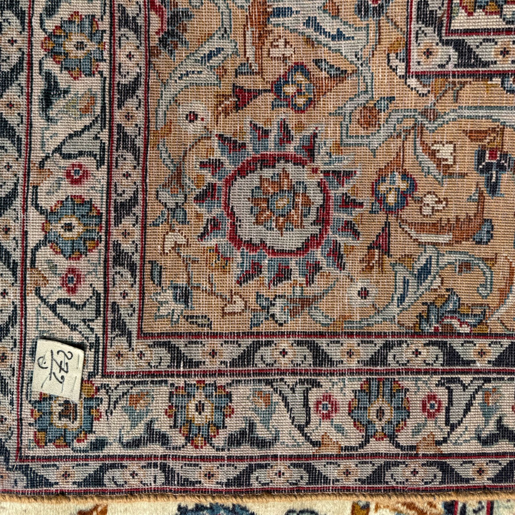 Kashan Persian rug, hand knotted, ivory ground rug, the rosette medallion decorated with projecting palmettes, on a field of swirling leafy branches and decorated with further palmettes, the scrolling border with repeating stylised plant motifs, within floral pattern guard stripes