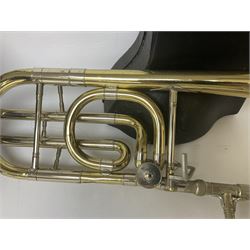 Three brass trombones comprising Elkhart Ind. USA 'CONN' model no.72H; Besson 'Concord'; and Selmer Distributed 'Lincoln'; two in carrying cases; and German B & M 'Champion' brass trumpet (4)