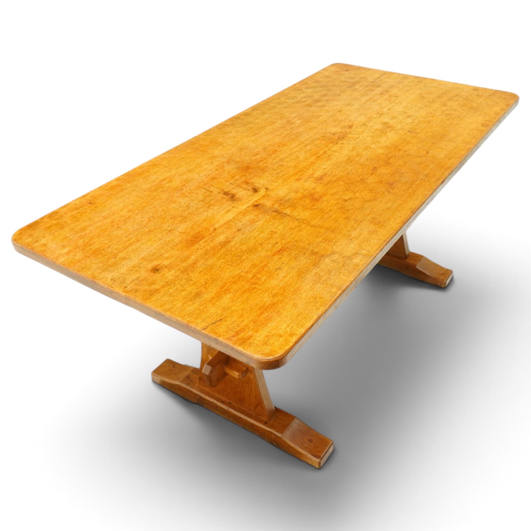 Acornman - adzed oak refectory dining table, rectangular adzed top with rounded corners raised on twin shaped end supports terminating to sledge feet united by pegged stretcher, carved with acorn signature