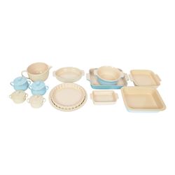Le Creuset ceramic kitchen wares in cream and light blue, including pie dishes, baking dis...
