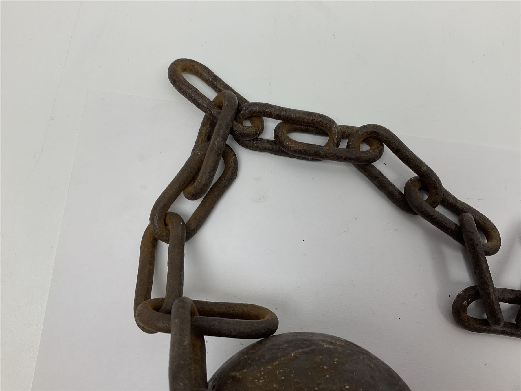 Late 19th/early 20th century prisoners iron ball and chain, with leg manacle; small cannon ball and grape shot