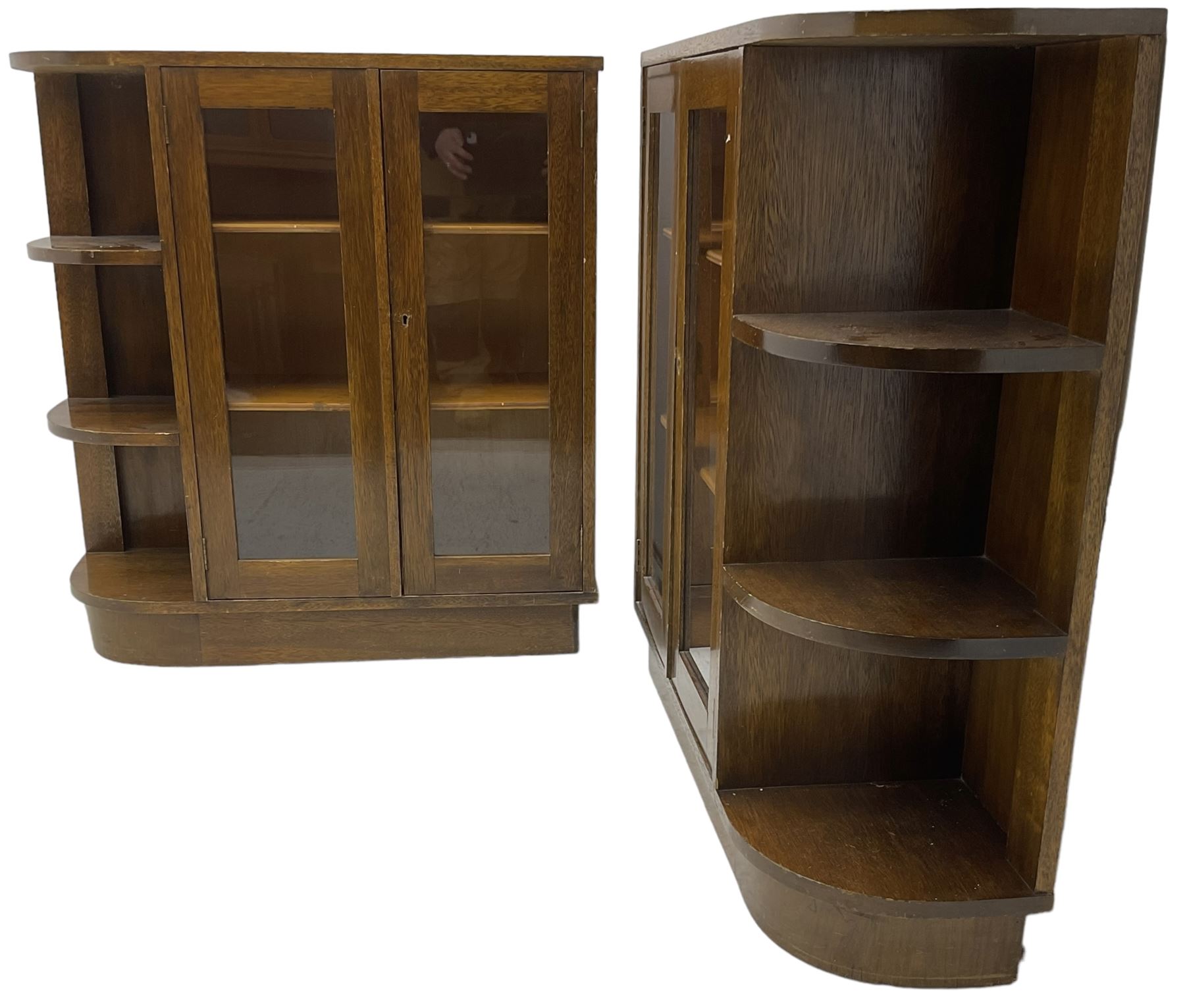Pair of mid-20th century oak bookcases, rectangular form with curved ends, enclosed by glazed doors and fitted with shelves