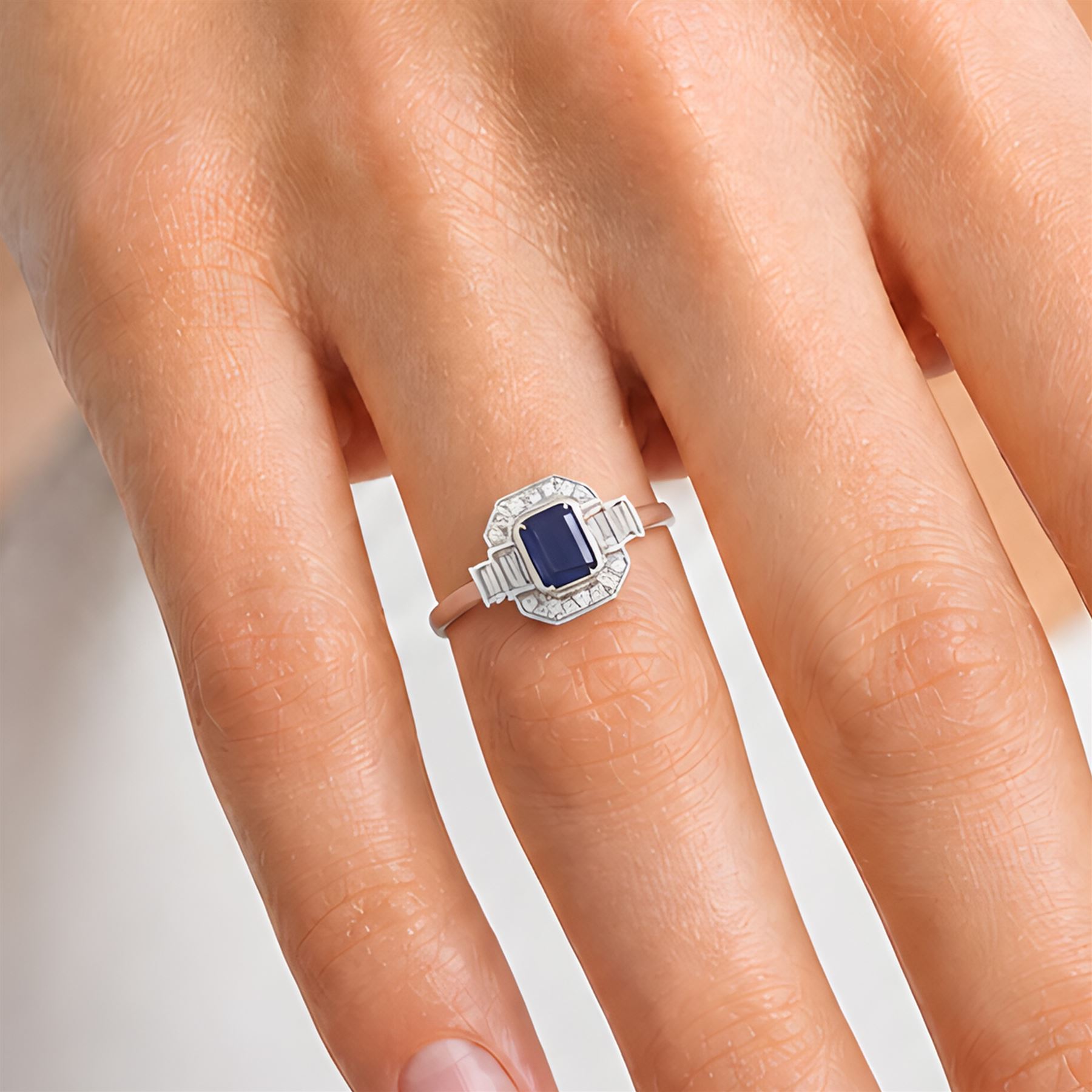 Platinum sapphire and diamond ring, single octagonal cut sapphire of approx 1.15 carat, flanked by two baguette cut diamonds and milgrain set round brilliant cut diamond surround, hallmarked, total diamond weight approx 0.35 carat