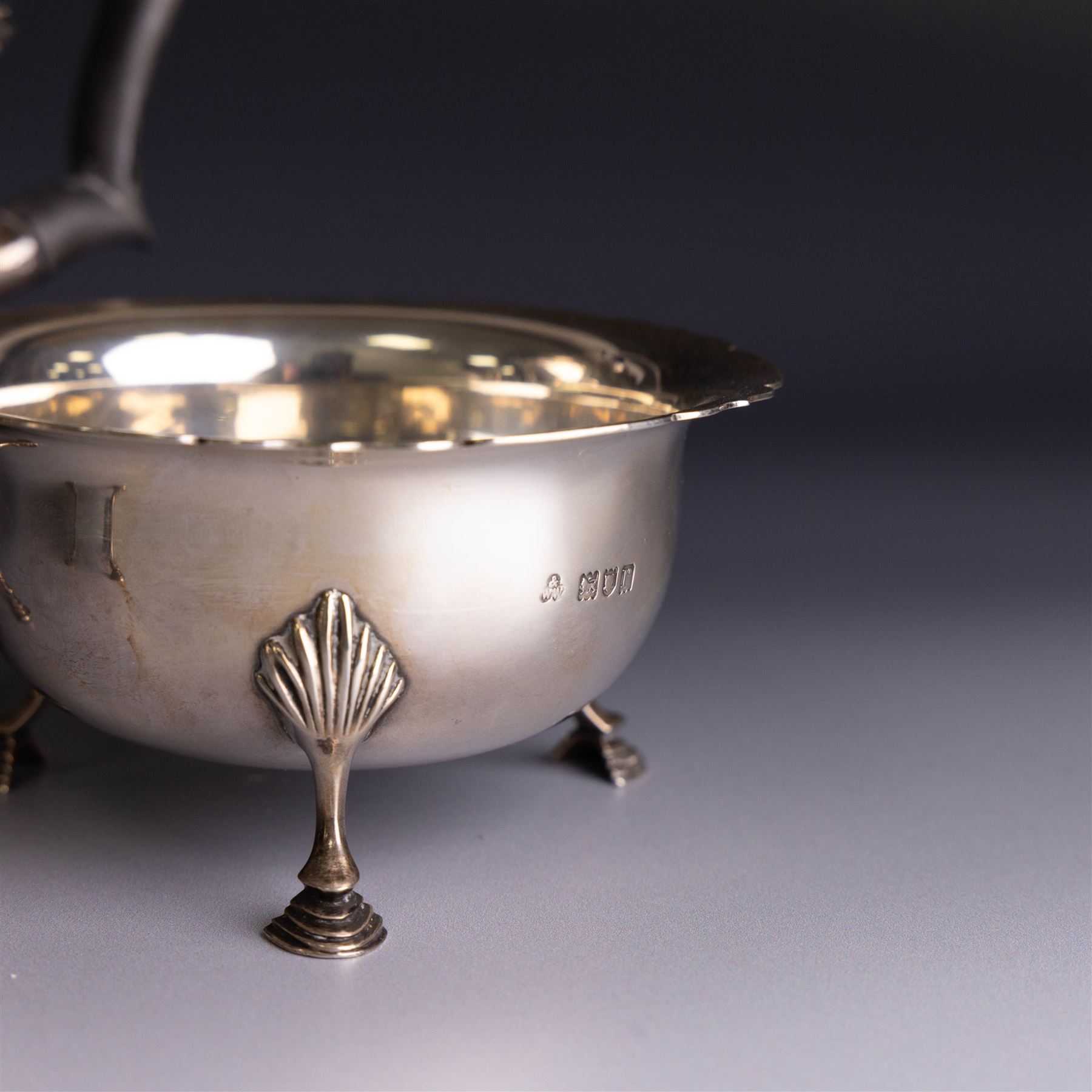 Early 20th century silver three piece bachelor's tea service, comprising teapot, open sucrier and milk jug, all of circular waisted form with shaped rims and upon three stepped feet, the teapot with ebonised wooden handle and finial, hallmarked Wakely & Wheeler, London 1914, teapot height H15cm