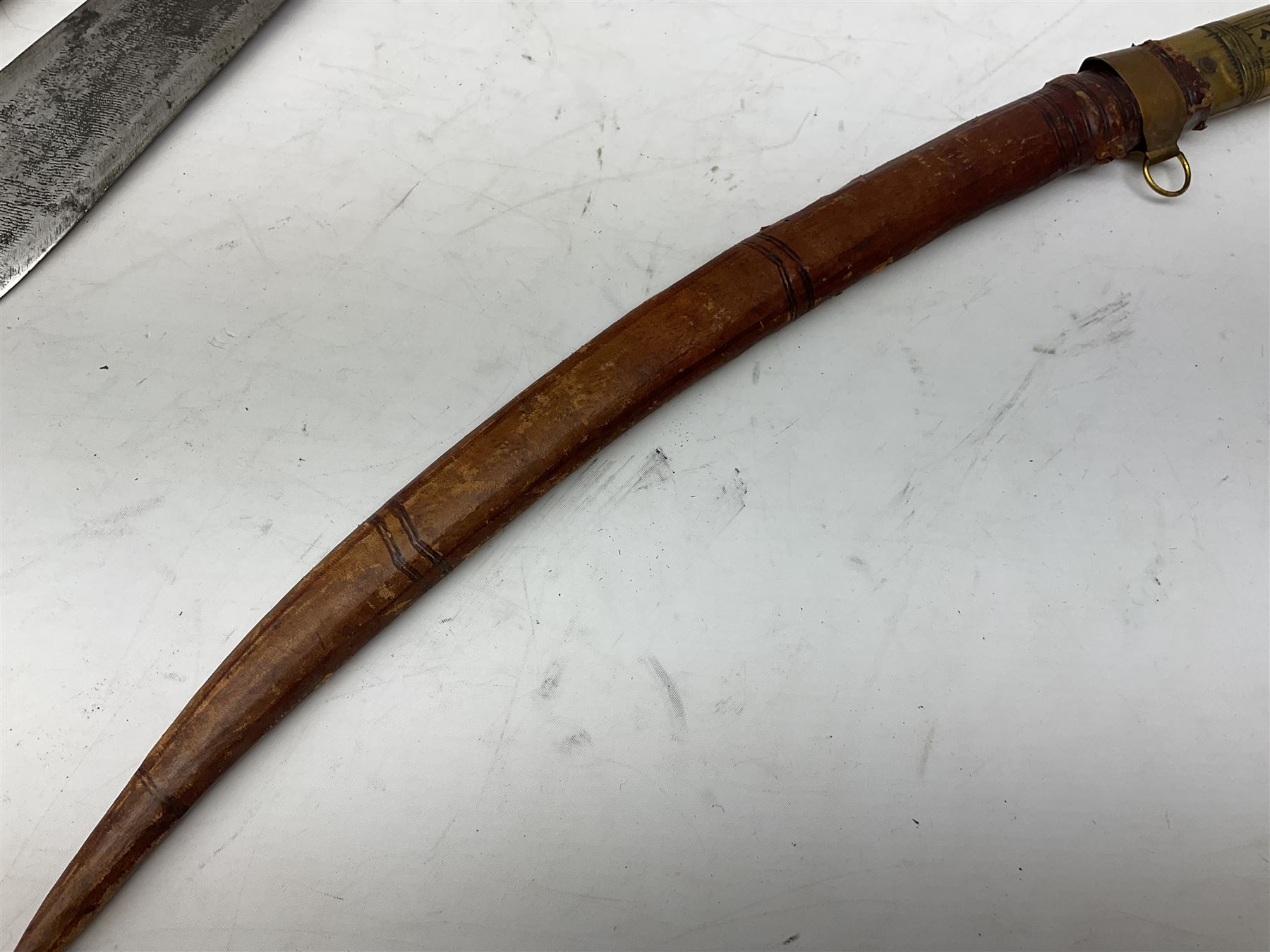 Near pair of African Moroccan Berber tribal Shula daggers each with engraved 39cm curving fullered steel blade, carved and inlaid horn grip and leather covered scabbard L57cm overall; kindjal style dagger with brass covered and jewelled grip and scabbard; another Eastern dagger with leather covered grip and scabbard; and a large Eastern knife with animal hide scabbard (5)