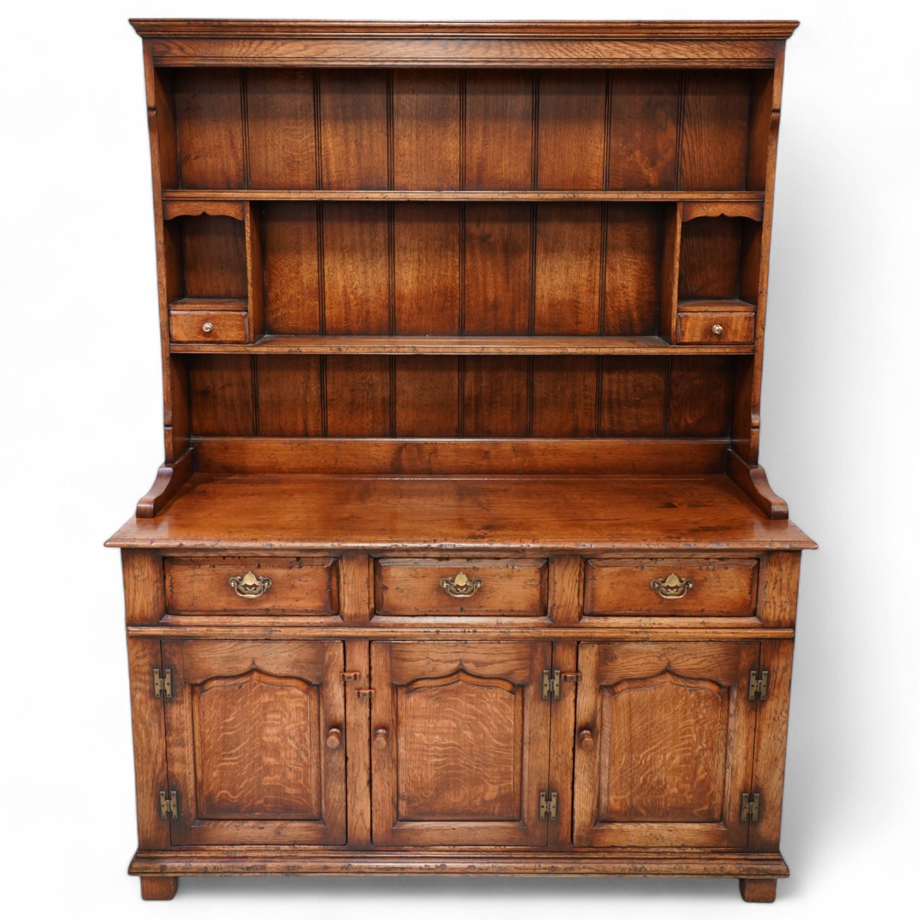 18th century design oak dresser, moulded cornice over two heights plate rack and two small drawers, the dresser base with moulded rectangular top over three drawers and three cupboards, enclosed by ogee arch panelled doors, on stile supports with applied lower moulding