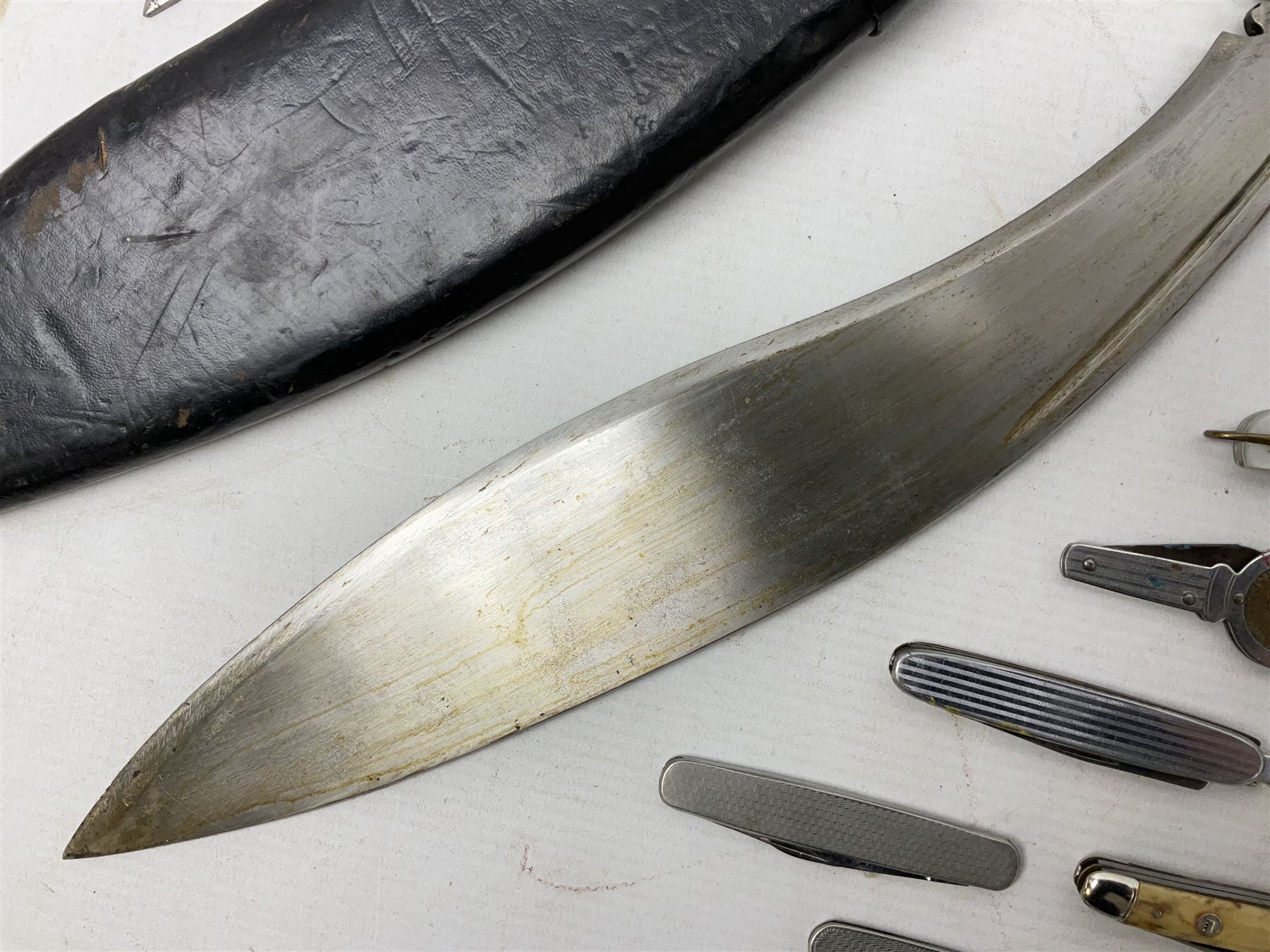 WW2 Gurkha Kukri knife with 34cm curving steel blade and horn handle; in leather covered scabbard with dual belt loops and two horn handled skinning knives L47cm overall; and collection of fourteen military and other folding and pocket knives including WW2 British Army clasp jacknife, J.H. Thompson C.C.1286 army knife dated 1954, Brookes & Crookes multiblade pocket knife etc (15)