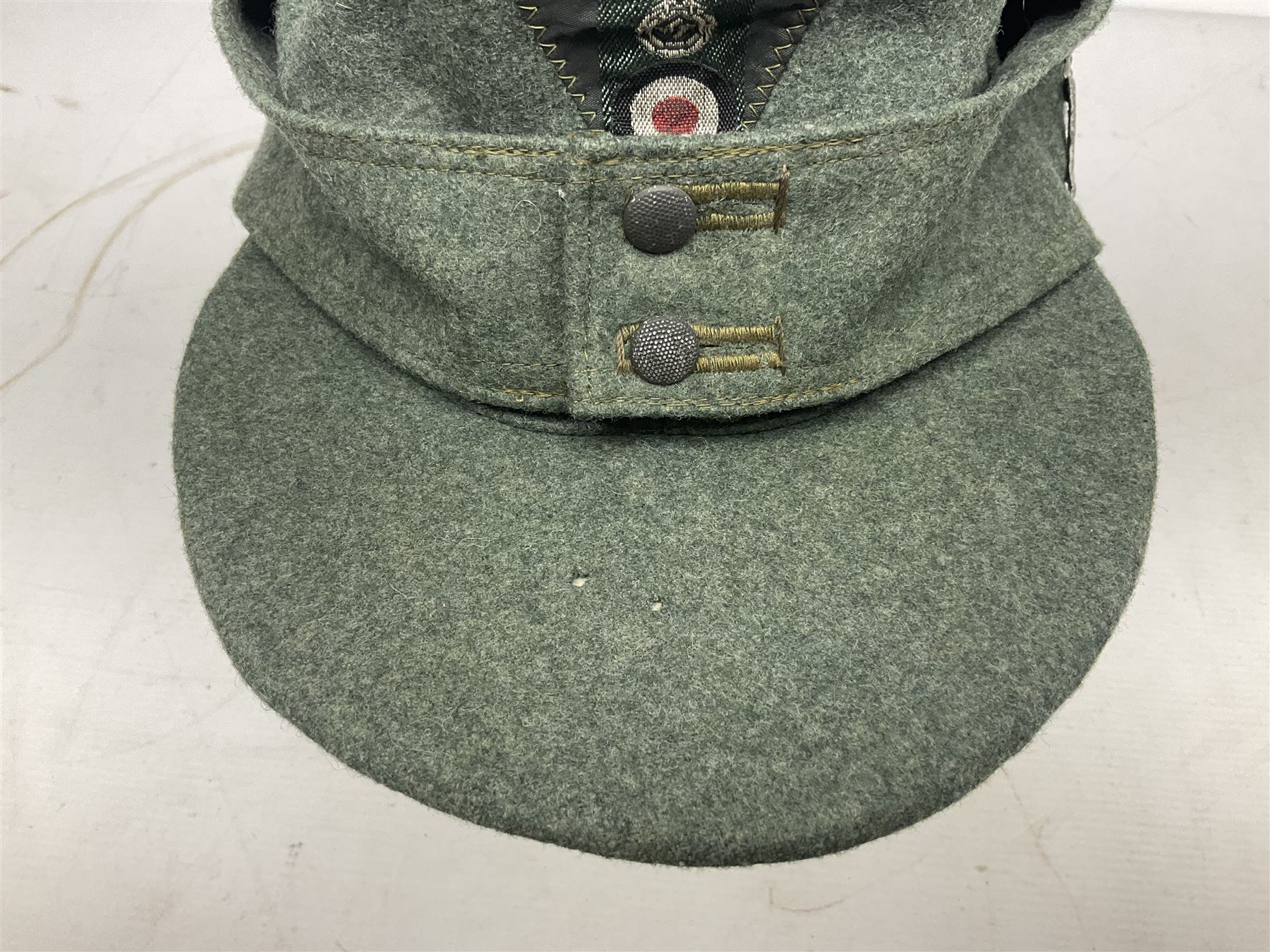 WW2 German Army M43 field cap with triangular cloth eagle and roundel badge and metal edelweiss badge for mountain troops; faintly stamped '5 VMF(?)'