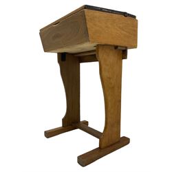  Early 20th century narrow oak school desk, fitted with ink well and hinge lid enclosing book compartment, raised on shaped supports and sledge feet joined by floor stretcher