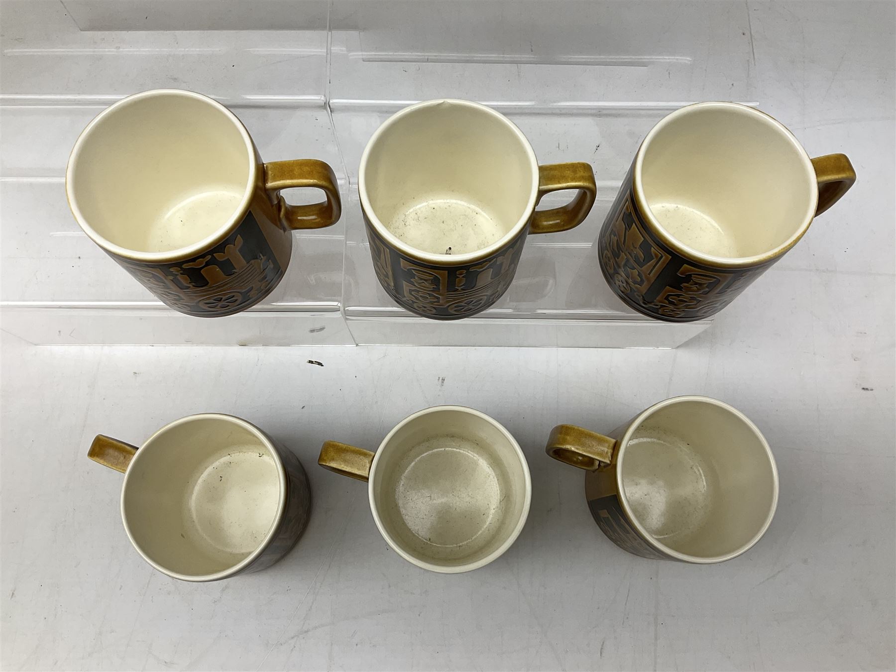 Collection of 1970s Hornsea mugs designed by John Clappison, comprising six Train Robber pattern examples together with owl patterned example on dark teal ground, and further example decorated with stylised hen and chick and egg, approx 9cm, together with four small cup bowls, all with stamped Hornsea marks beneath