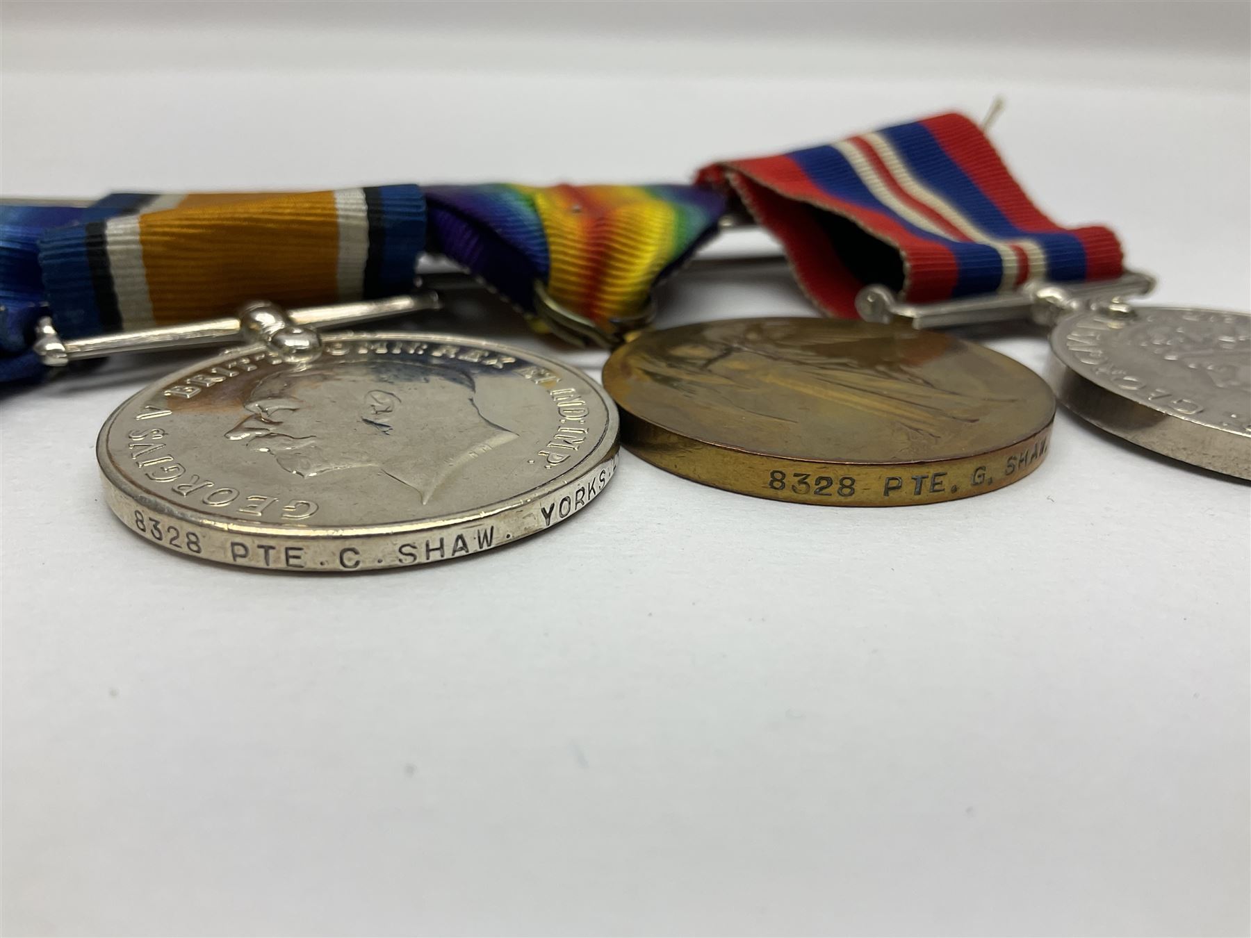 WW1 group of three medals comprising British War Medal, Victory Medal and 1914 Star awarded to 8328 Pte. G. Shaw Yorks: L.I.; on hanging bar with WW2 1939-1945 War Medal and WW1 ribbon bar with rosette to 1914 Star ; all with ribbons; and WW2 1939-1945 War Medal with ribbon
