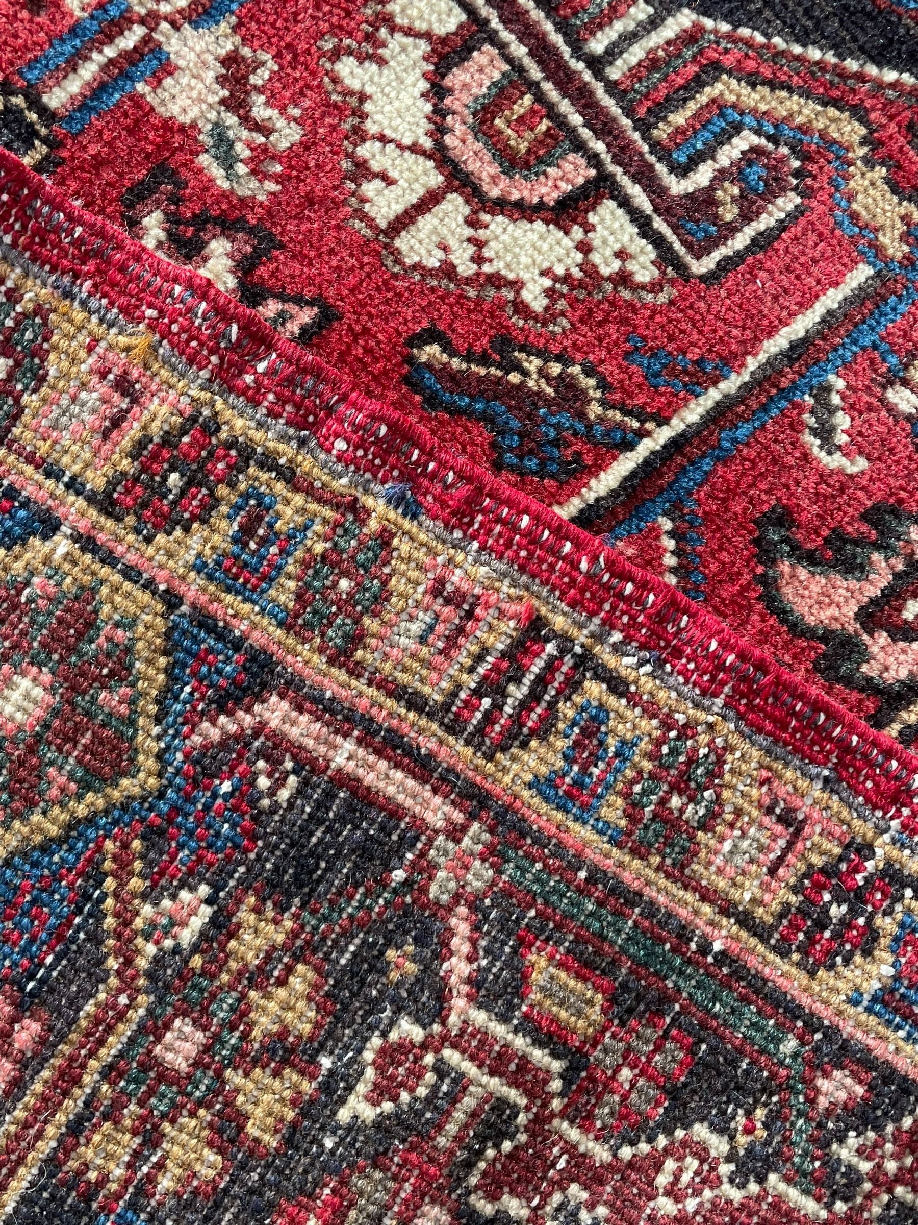 Persian Heriz red ground rug, large medallion decorated with palmettes and Ejder motifs, the border decorated with stylised plant motifs, within floral design guard stripes 