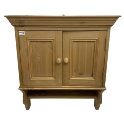 Small pine occasional table, fitted with single drawer over under-tier (W59cm, H74cm, D38cm); and a wall hanging pine cupboard enclosed by two panelled doors (W72cm, H78cm, D26cm)